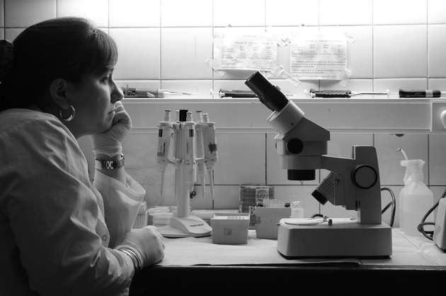 científica  mirando al microscopio